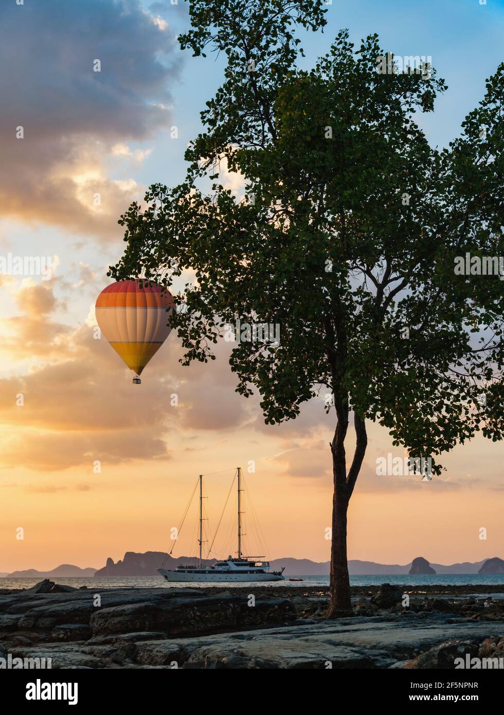 Thailand coastline, hot air balloon over sea and yacht in marine at sunset Stock Photo
