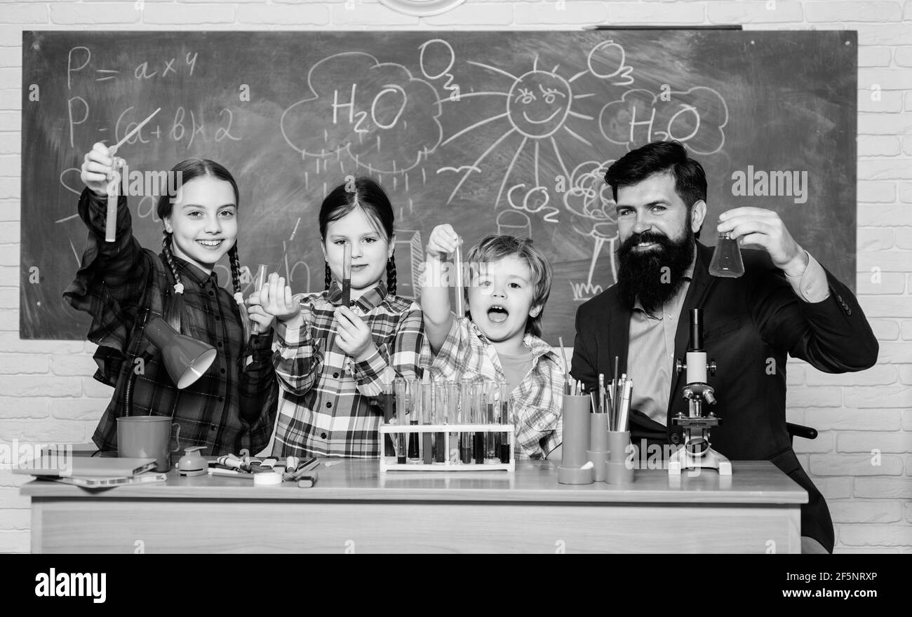 Looking at future of science. happy children & teacher. back to school. experimenting with chemicals or microscope at laboratory. biology education Stock Photo