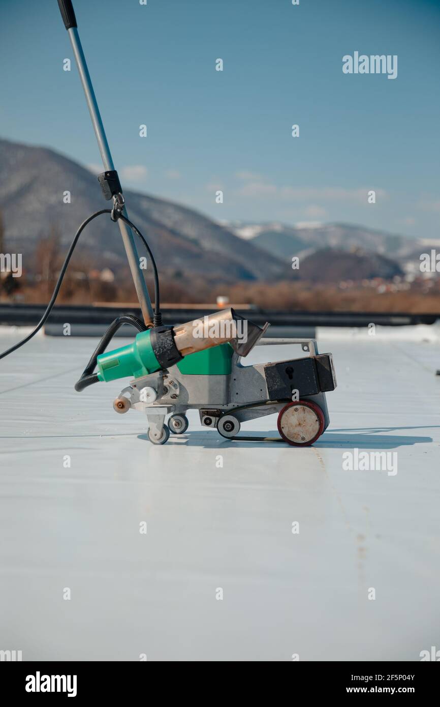 Automatic welder hot-air tools welds synthetic membranes on roof. Stock Photo