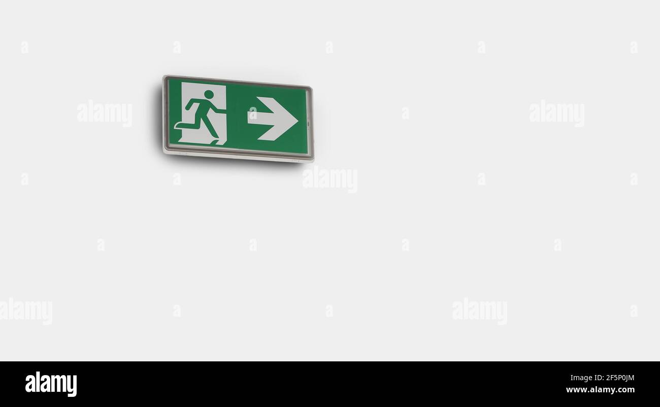 Emergency exit sign on the white wall background Stock Photo