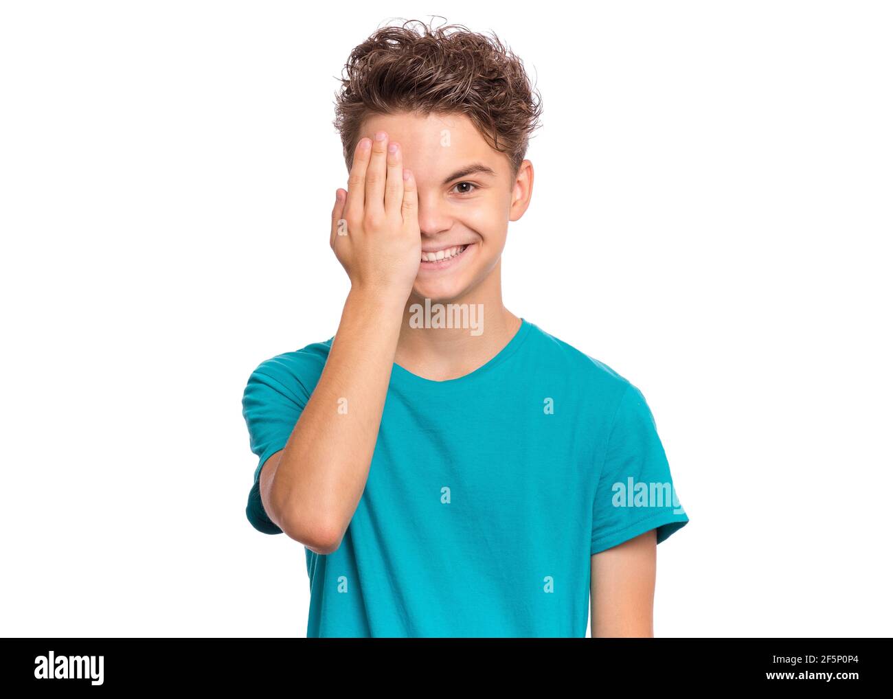 Handsome teen boy looks with one eye while covering his other eye with ...