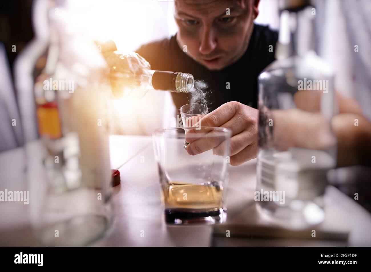 man with an alcohol problem drinks alcohol alone in a den Stock Photo