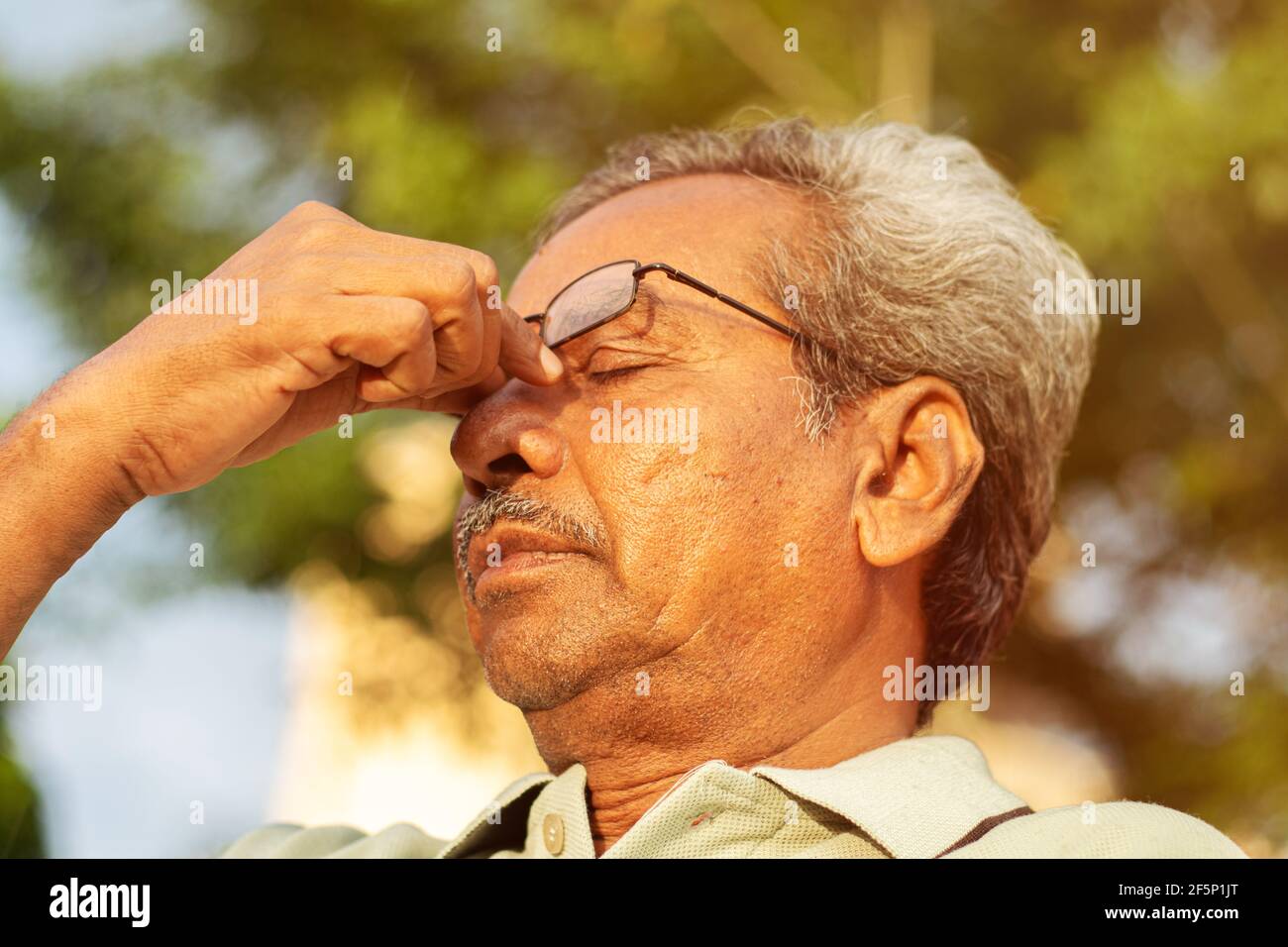 Head shot of worried senior old man rubbing his eyes - conept of healthcare, medical and stressed out elderly people Stock Photo