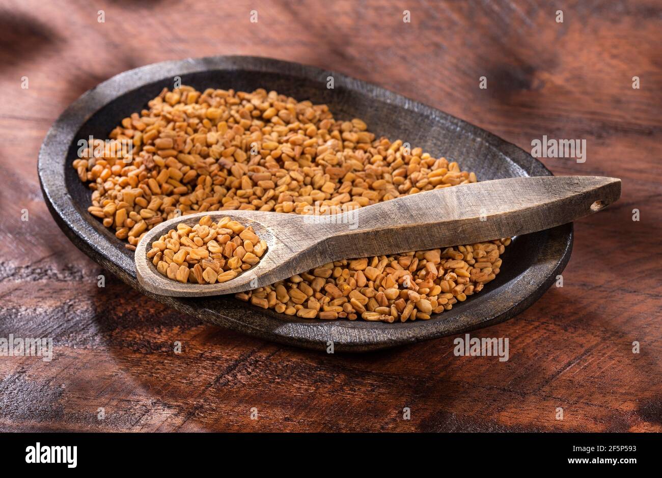 Organic fenugreek seeds in the bowl. Trigonella foenum-graecum Stock Photo
