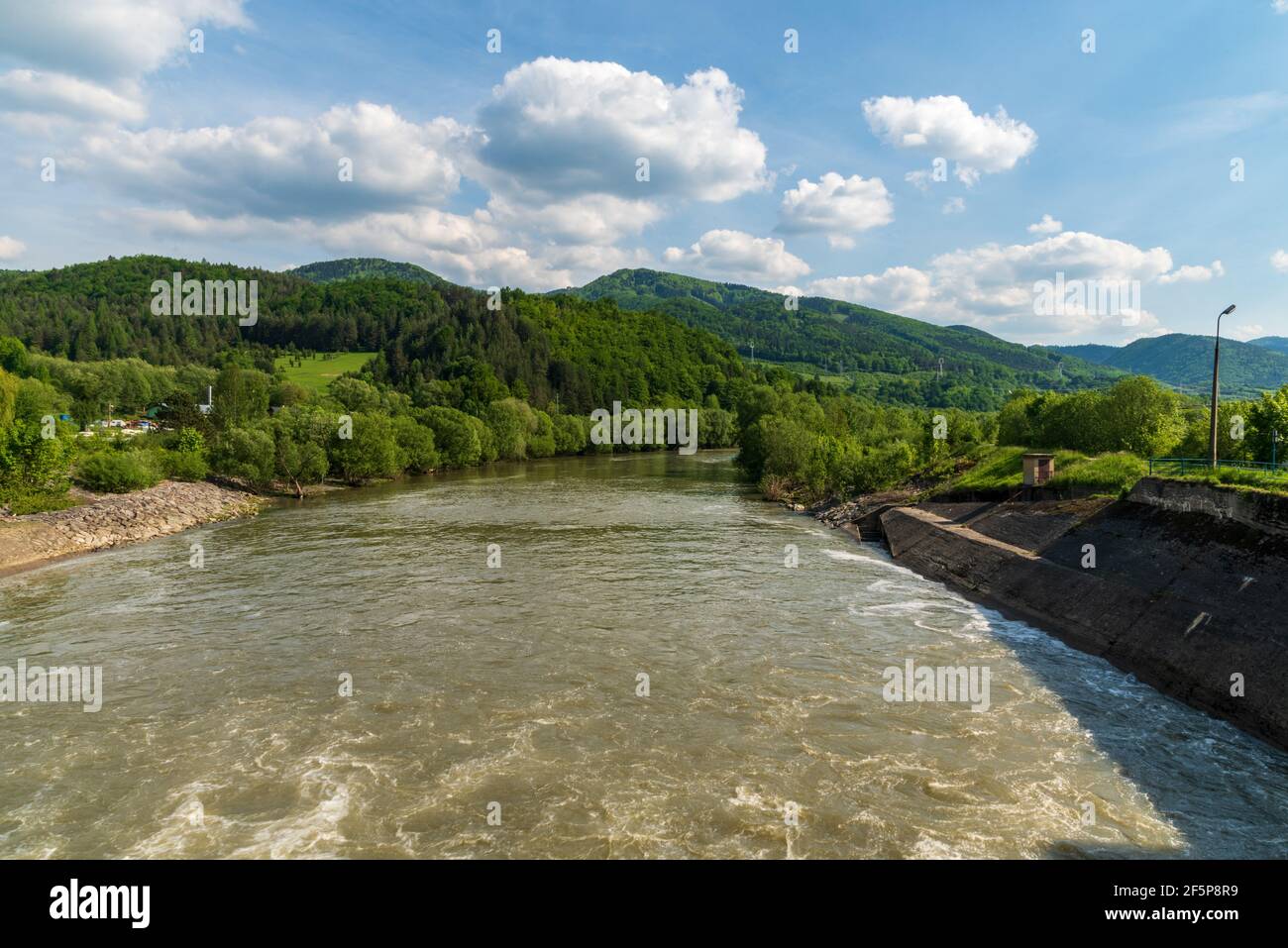 Vah river with hills of Velka Fatra mountains near Krpelany village in Slovakia during beautiful springtime day Stock Photo