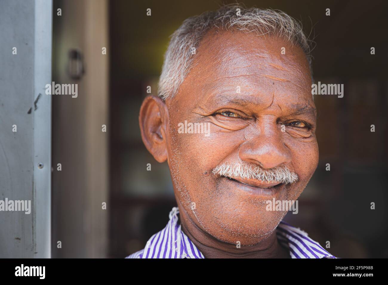 Kandy, Sri Lanka - March 20 2019: Close-up street portrait of a cheerful, smiling, local elderly Sri Lankan man in Kandy, Sri Lanka. Stock Photo