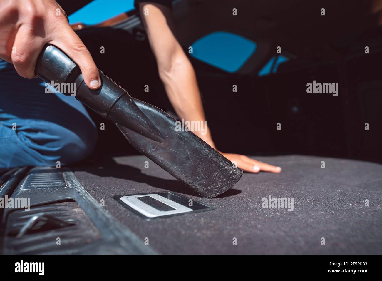 Man cleaning car inside with vacuum cleaner at self service car wash