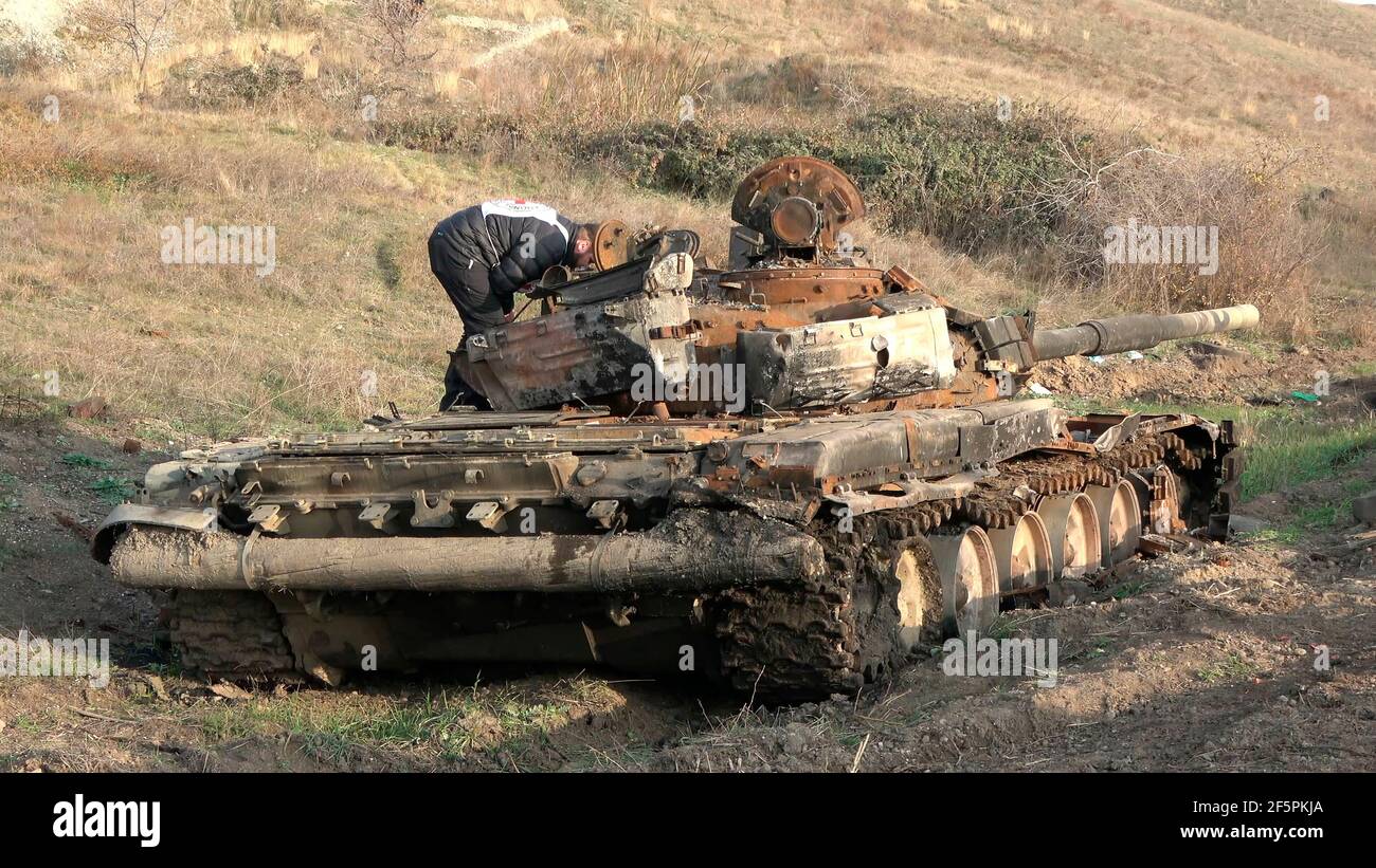 JABRAYIL, AZERBAIJAN - DECEMBER 15: A member of the International Committee of the Red Cross examine a destroyed Armenian T-72 tank for remains of Armenian fighters killed in the conflict over the disputed region of Nagorno-Karabakh on December 15 2020 in the Jabrayil Rayon of Azerbaijan. Heavy clashes erupted over Nagorno-Karabakh in late September during which more than 5,600 people, including civilians, were killed. The sides agreed to a Russia-brokered cease-fire deal that took effect on November 10 Stock Photo