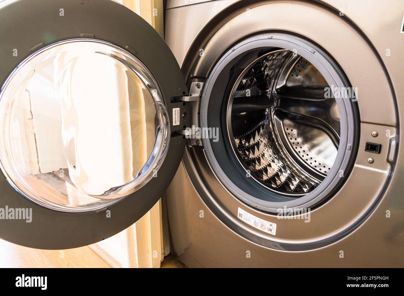 Empty washing machine drum with door open in a house hold setup Stock