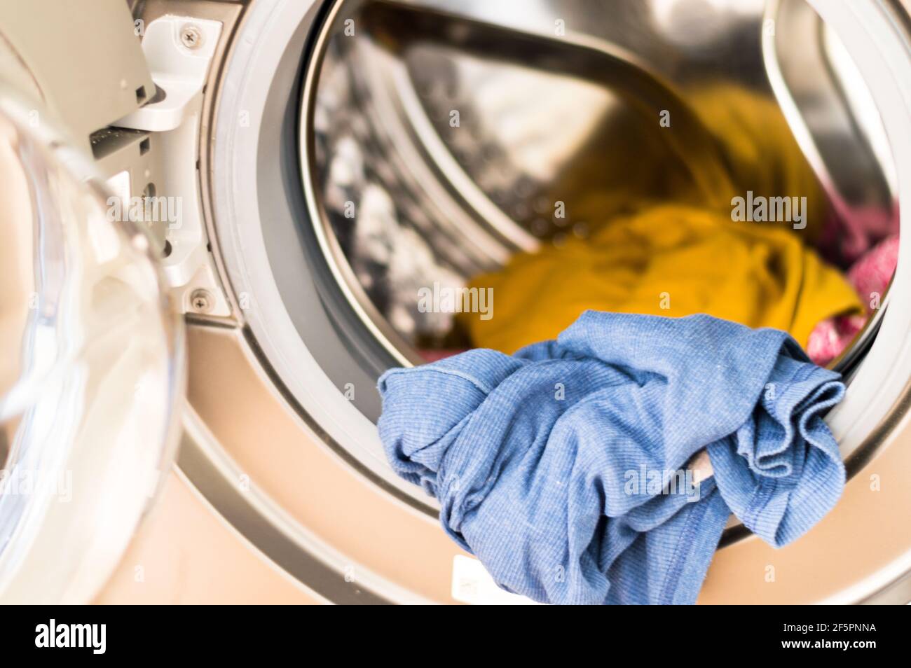 Clothes in washing machine for laundry at home Stock Photo