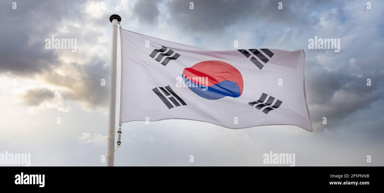 South Korea sign symbol. South Korean national flag on a pole waving against cloudy sky background. Stock Photo
