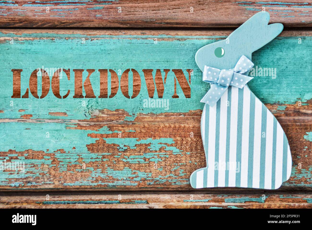 Lockdown and Easter bunny on wooden background Stock Photo