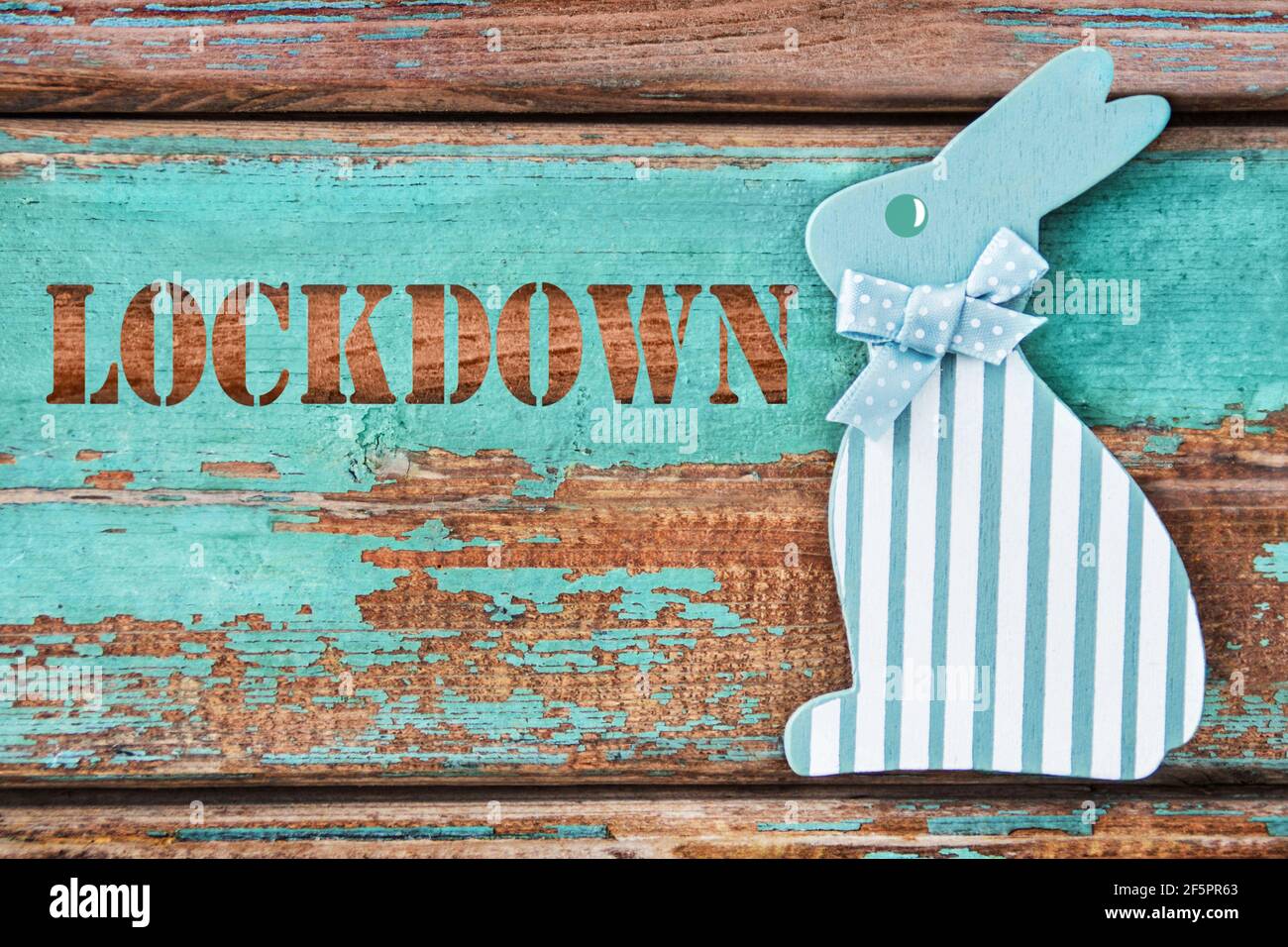 Lockdown and Easter bunny on wooden background Stock Photo