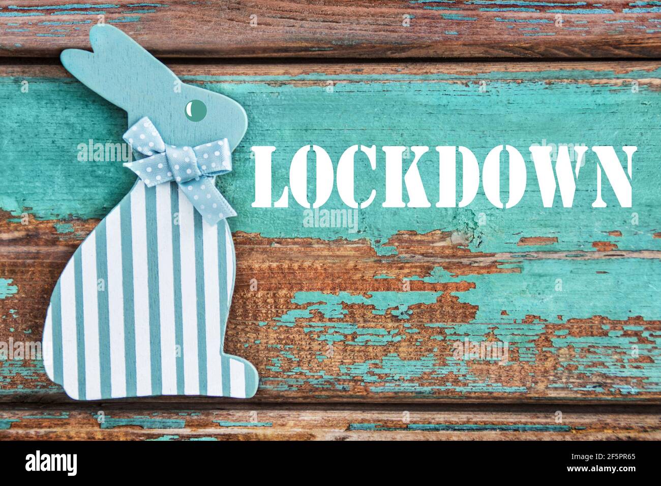 Lockdown and Easter bunny on wooden background Stock Photo