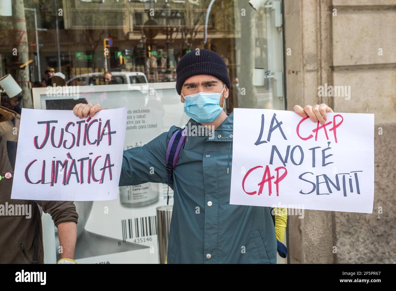 Barcelona, Catalonia, Spain. 27th Mar, 2021. Protester is seen with banners that say, climate justice and CAP (Common Agrarian Policy) does not make any sense.The Barcelona representatives of Animal Rebellion, an international movement for the fight for a sustainable food system, climate justice and defense of animals has carried out, that Saturday, March 27, in front of the Headquarters of the European Union Commission in Barcelona a direct action non-violent to ask the Directorate General for Agriculture and Rural Development of the European Commission to withdraw the current CAP (Credit Im Stock Photo