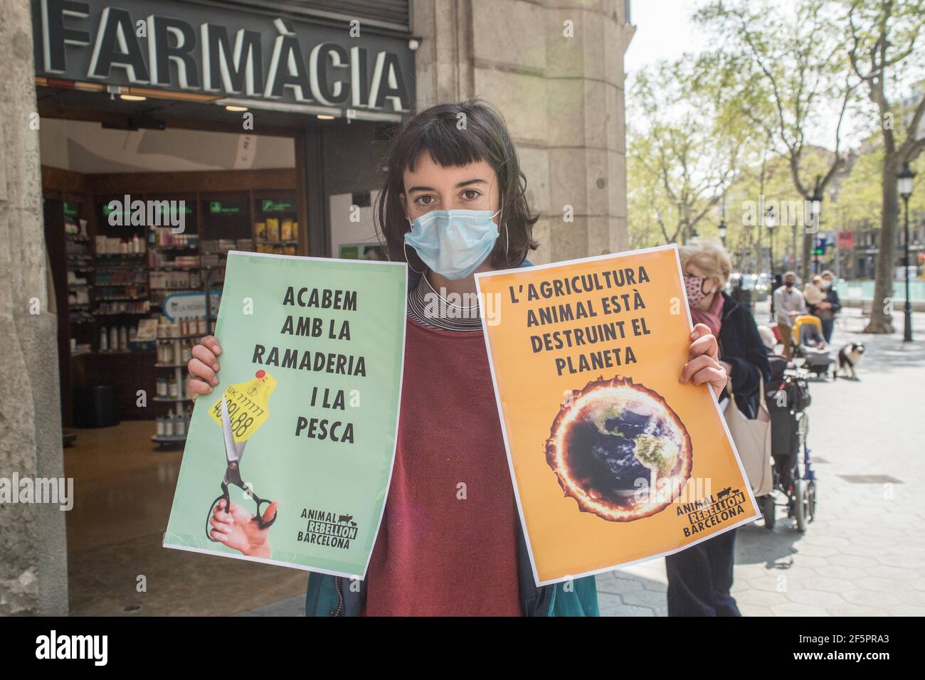 Barcelona, Catalonia, Spain. 27th Mar, 2021. Protester is seen with banners that say, end livestock and fishing and Animal agriculture is destroying the planet.The Barcelona representatives of Animal Rebellion, an international movement for the fight for a sustainable food system, climate justice and defense of animals has carried out, that Saturday, March 27, in front of the Headquarters of the European Union Commission in Barcelona a direct action non-violent to ask the Directorate General for Agriculture and Rural Development of the European Commission to withdraw the current CAP (Credit I Stock Photo