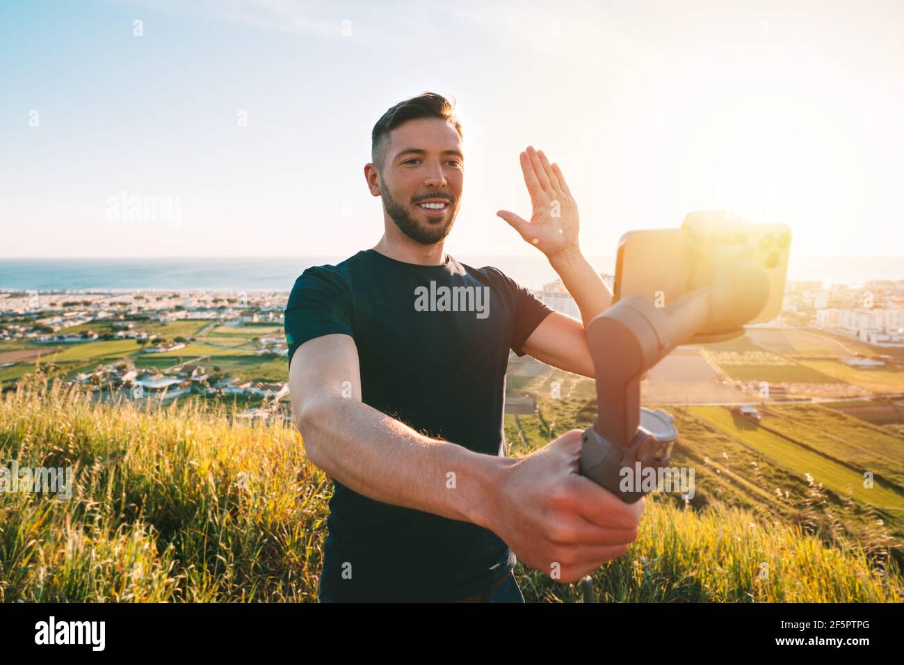 Man blogger records video blog or live streaming with phone and gimbal outdoors Stock Photo