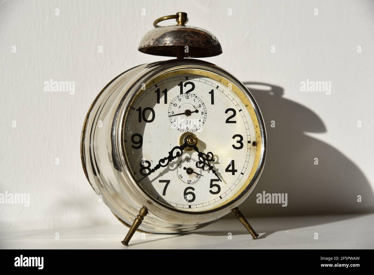 old clock in front of white wall Stock Photo