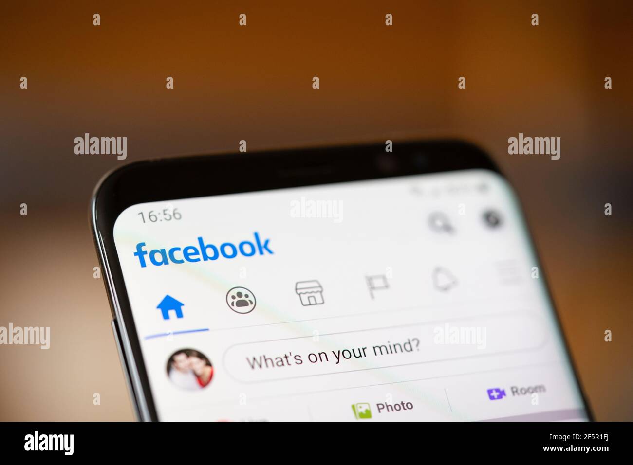 Closeup on an Android smartphone screen showing the Facebook social media app logo and home page Stock Photo