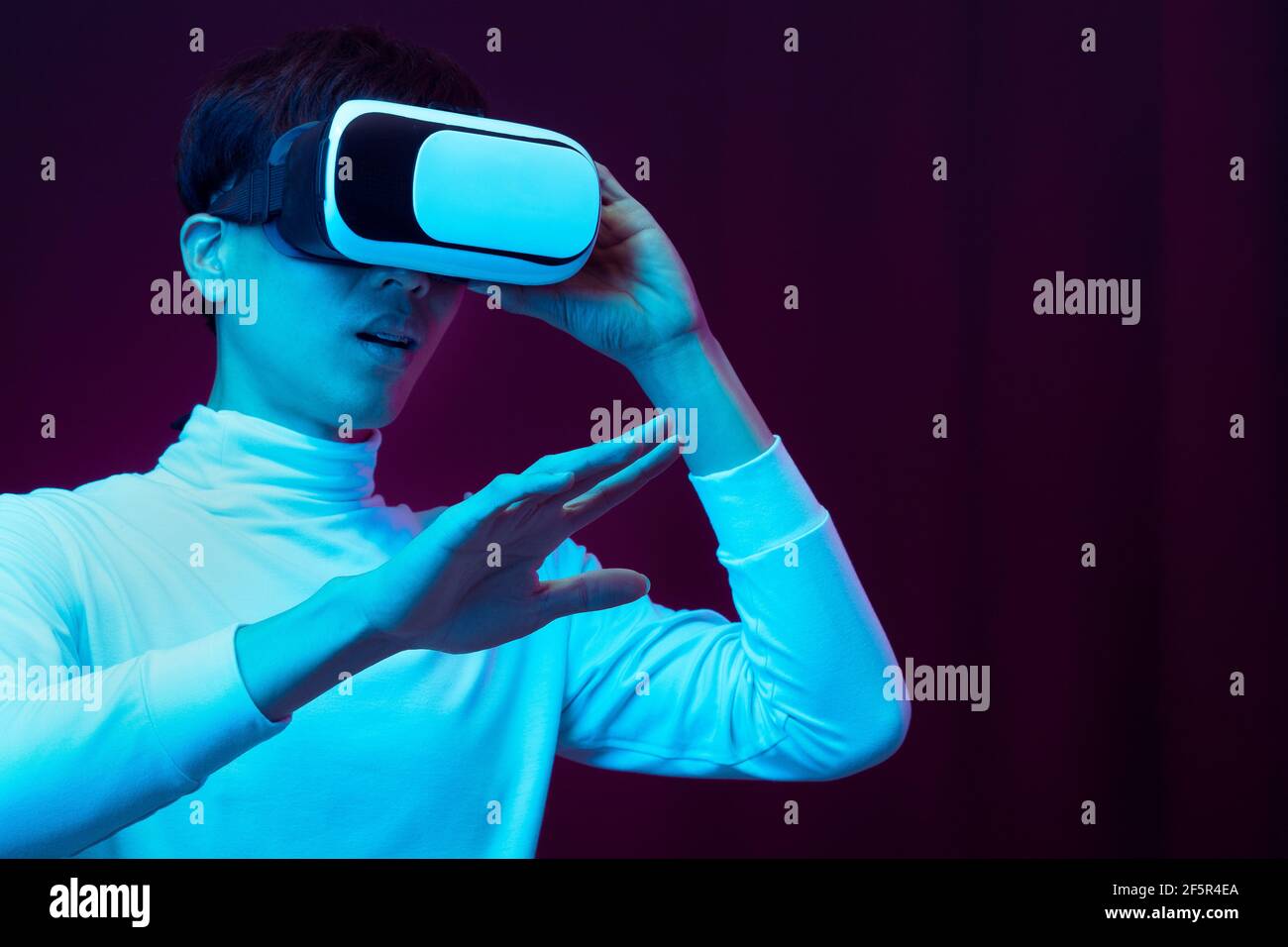 Excited asian young man wearing VR headset in neon light, Future ...
