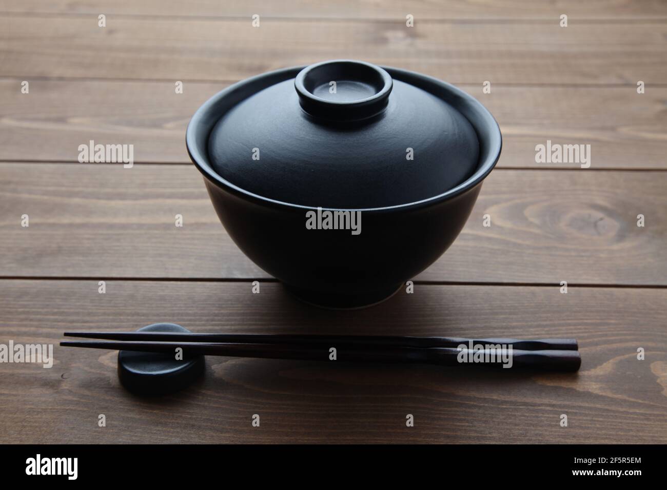 donburi rice bowl black isolated on wooden table Stock Photo
