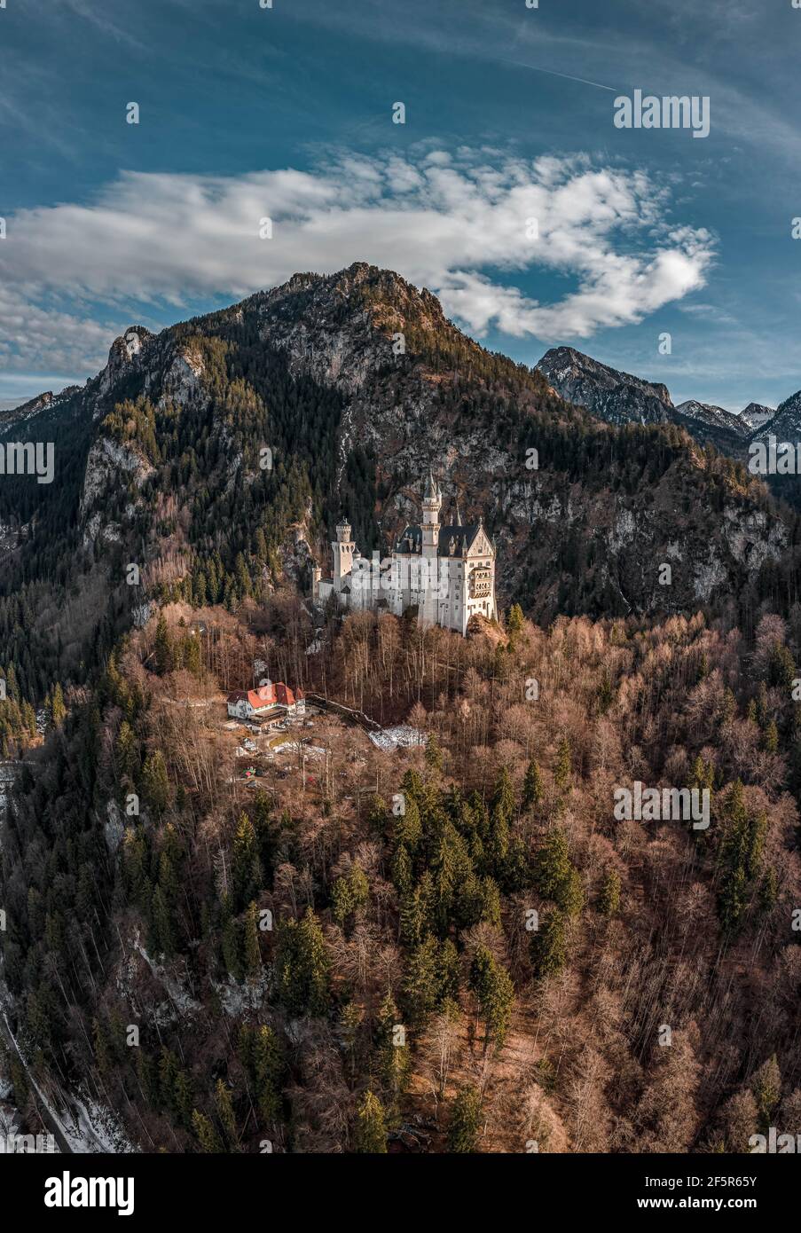 Aerial drone shot of picturesque Neuschwanstein Castle on snowy hill in winter sunlight in Germany Stock Photo