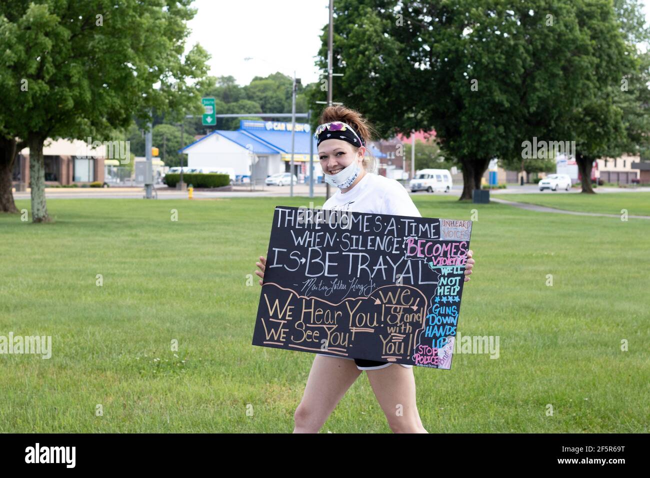 Smiling White woman at Peaceful Protest with colorful Poster for BLM Black Lives Matters Stock Photo