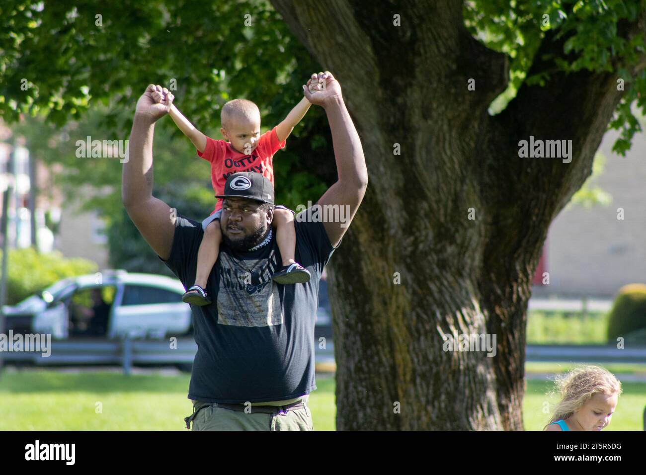 African American Dad - Father carrying Young Son or toddler at protest Stock Photo