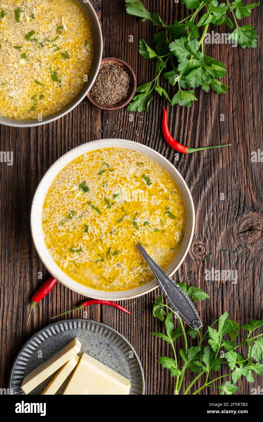 Quick and simple spicy egg drop soup with parsley and chilli on rustic wooden background Stock Photo