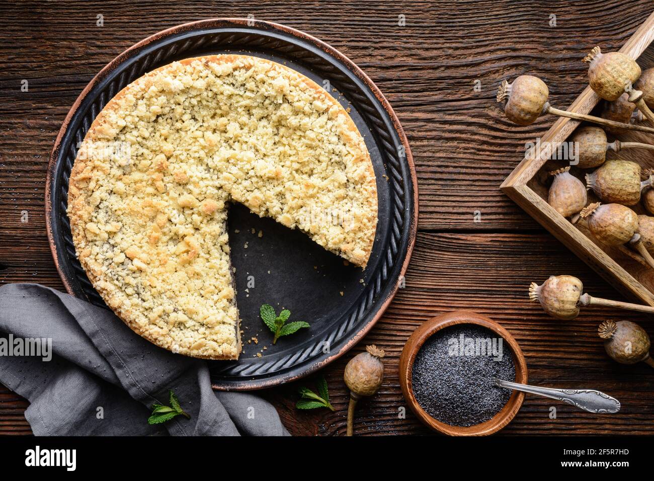 Mohnkuchen, German poppy seed cake topped with crunchy streusel on rustic wooden background Stock Photo