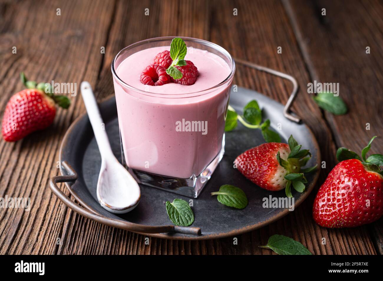 Healthy drink, strawberry and raspberry smoothie with Greek yogurt in a glass jar on rustic wooden background Stock Photo