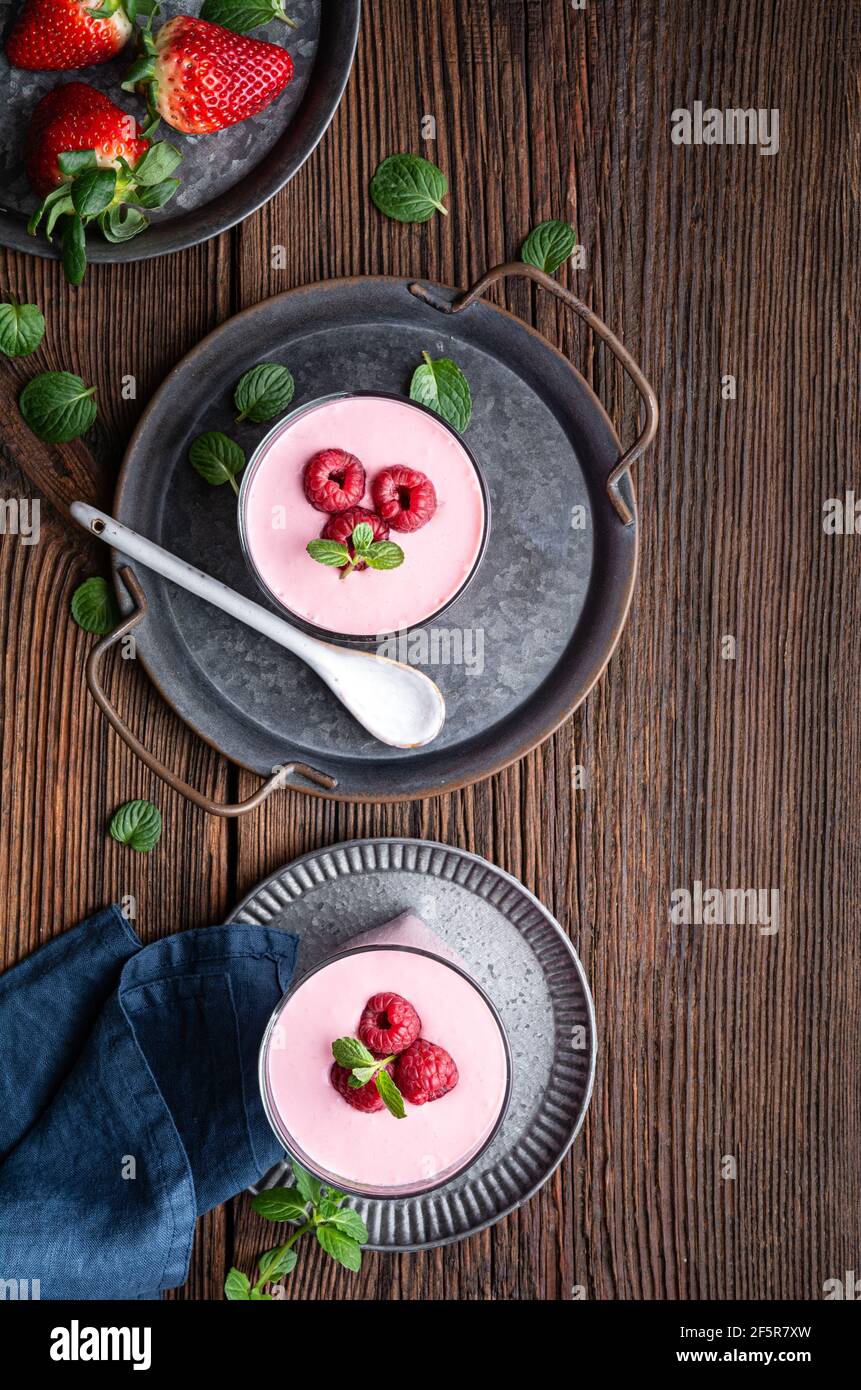 Healthy drink, strawberry and raspberry smoothie with Greek yogurt in a glass jar on rustic wooden background Stock Photo