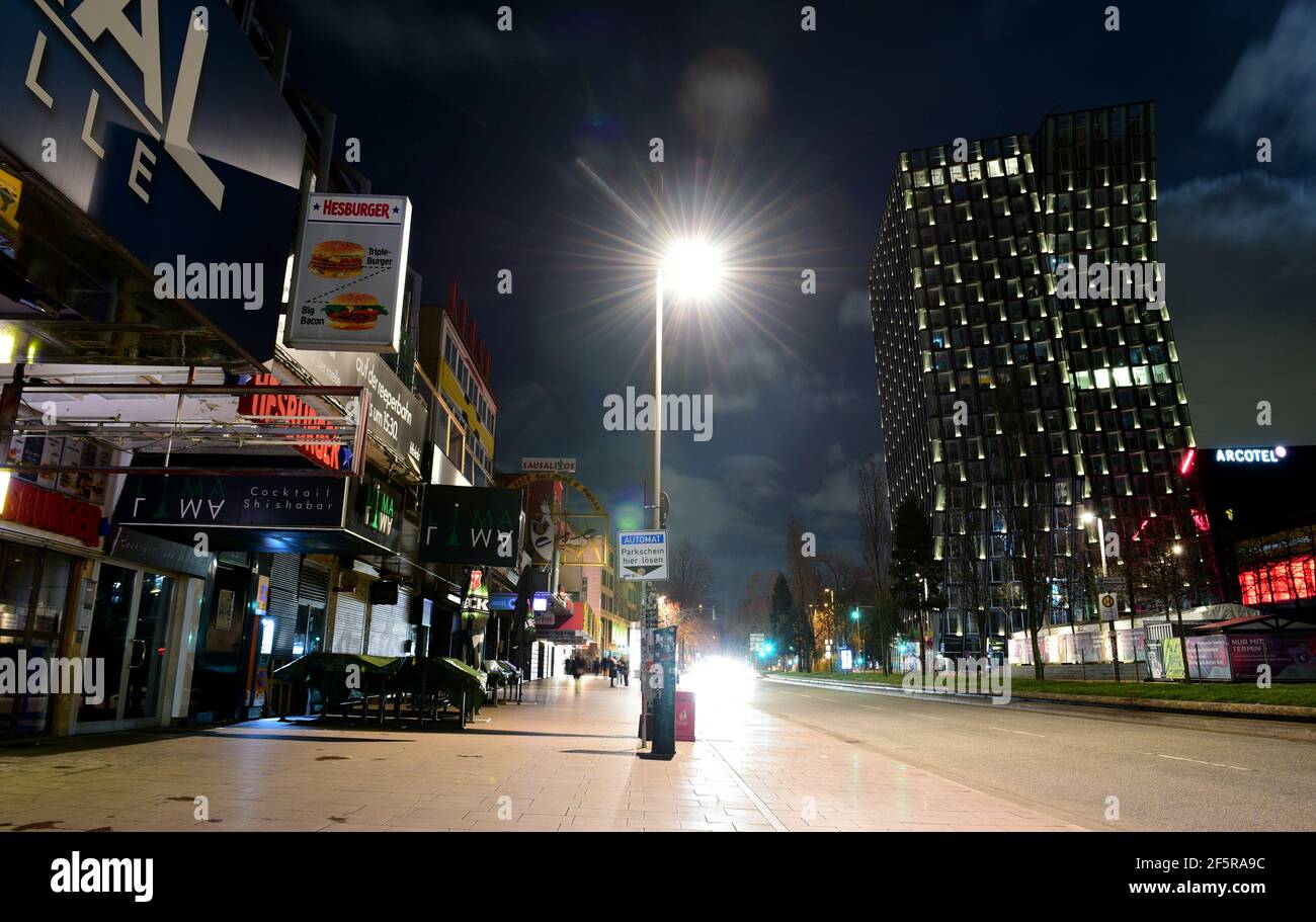 Hamburg, Germany. 27th Mar, 2021. Some bars and shops are unlit during  "Earth Hour" on the Reeperbahn. On the right you can see the "Dancing  Towers". Starting at 8:30 p.m., numerous lights
