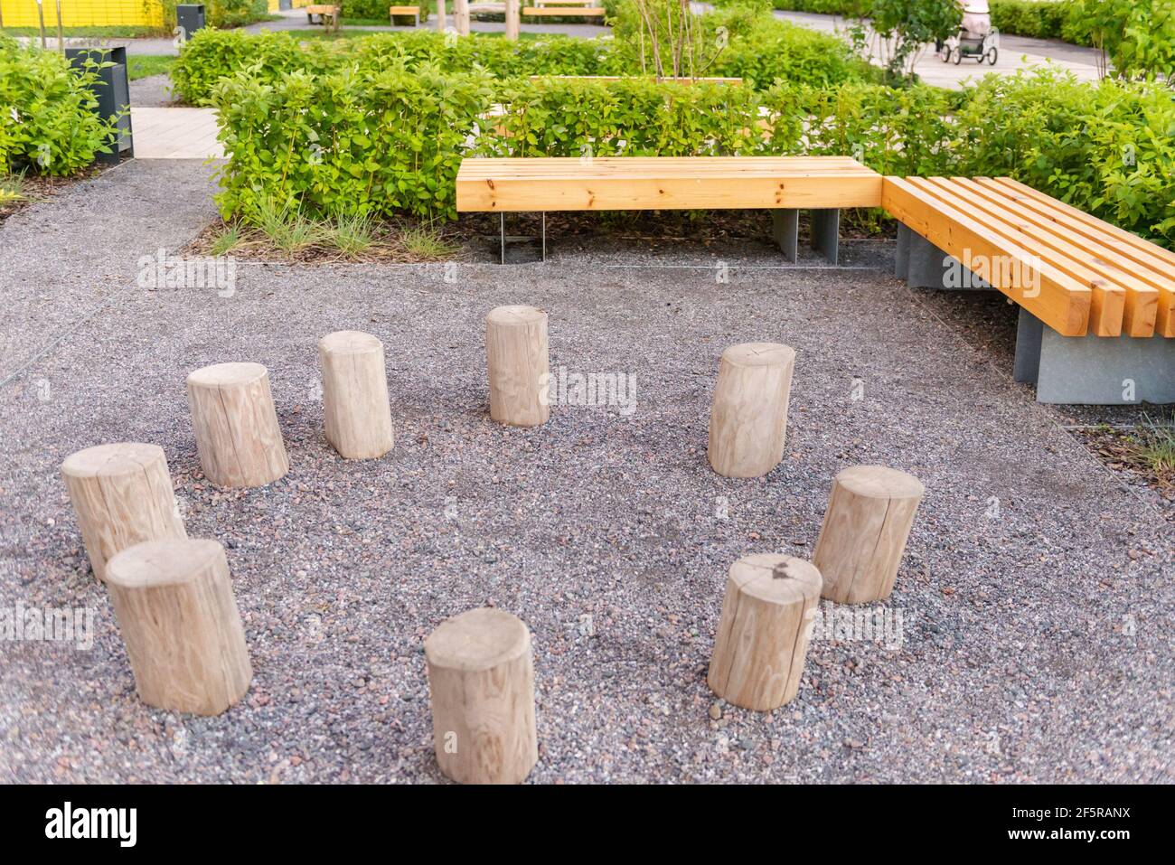 Landscaping in front of the entrance of the house. Benches and tree stumps. Corner at the entrance with fine gravel. Stock Photo