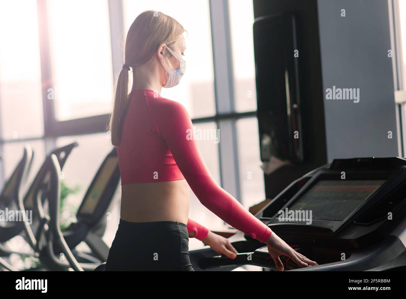 Woman wearing face mask exercise workout in gym during corona virus