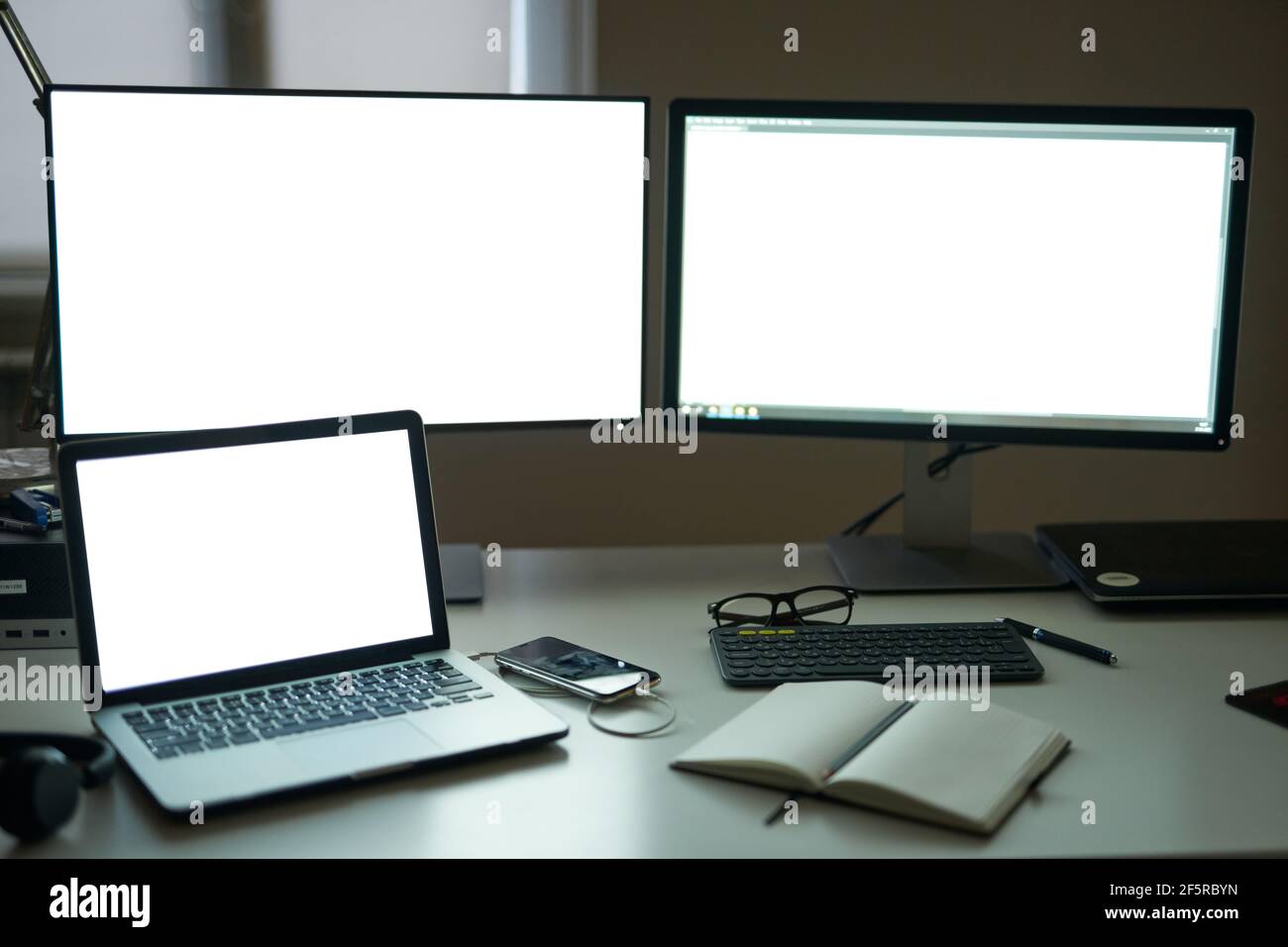 Many blank white screen of computer monitors with accessories and work  tools on modern freelance working space Stock Photo - Alamy