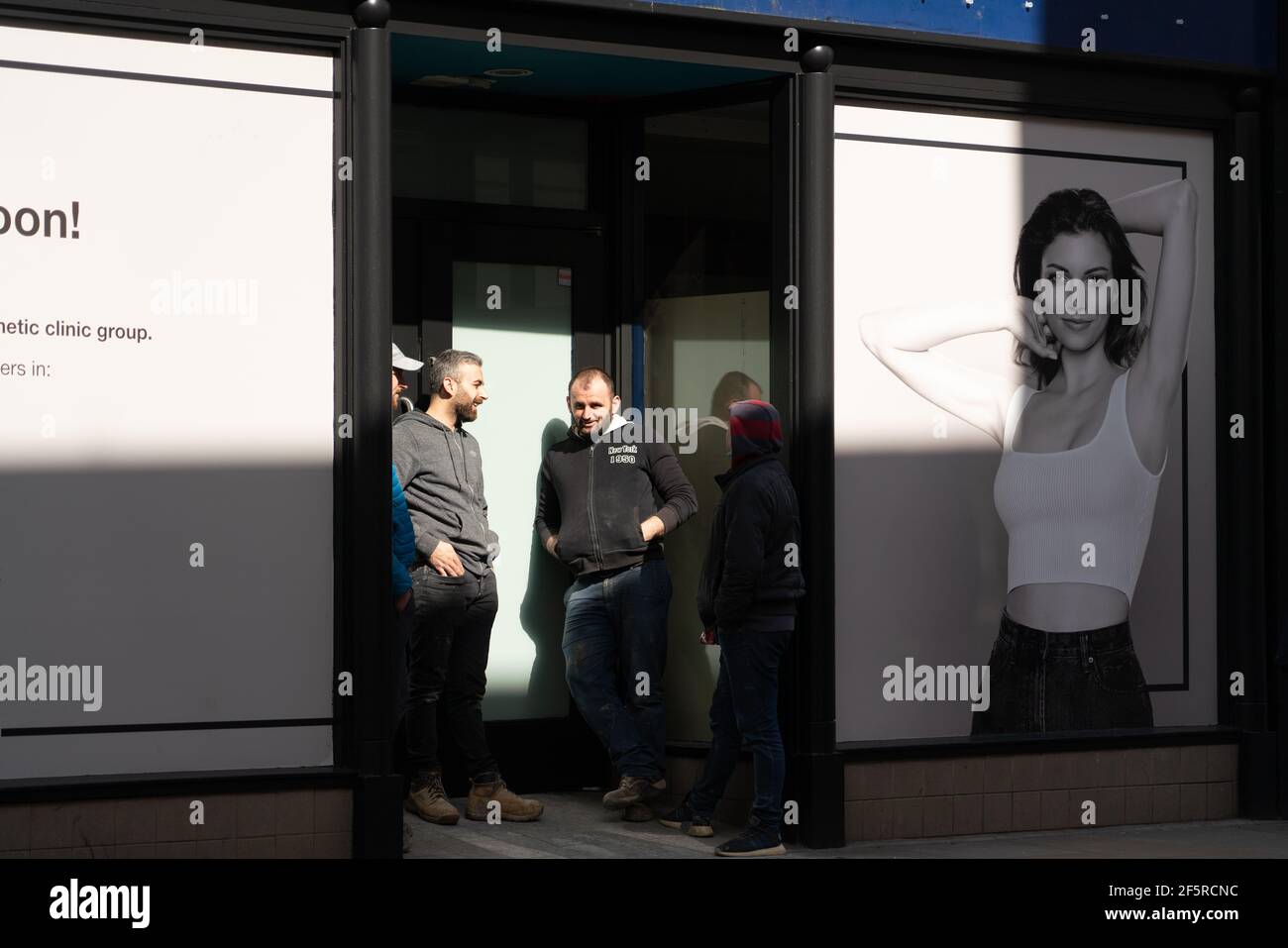 Decorators and builders outside a closed up shop on Richmond high