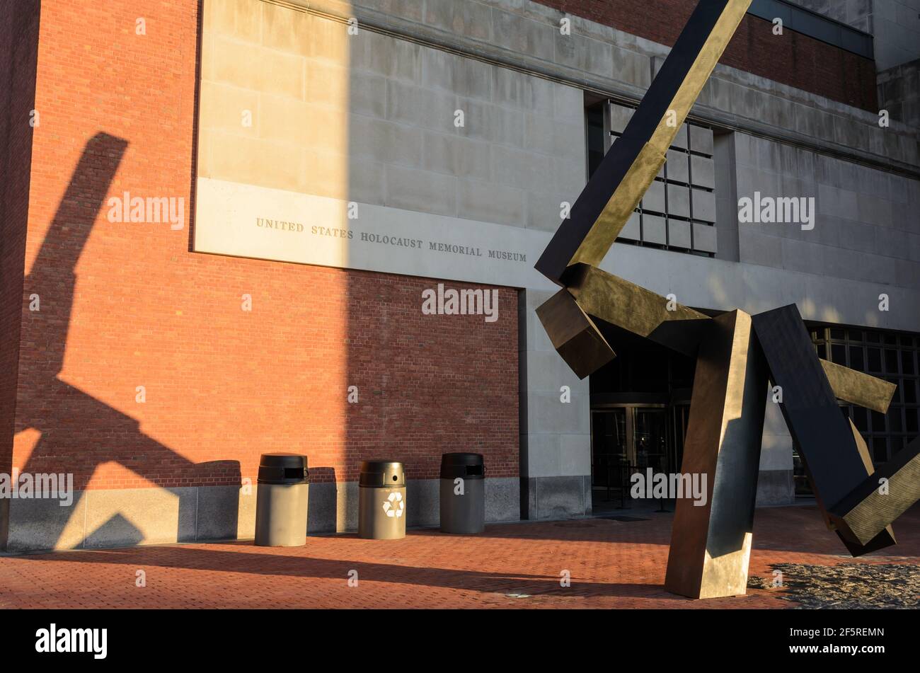 Loss and Regeneration Sculpture outside the US Holocaust Memorial Museum casting shadows on the building as the sun sets. Stock Photo