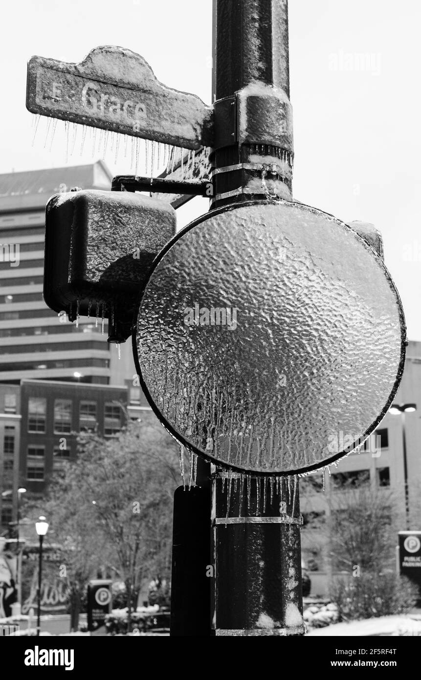 An iced up traffic mirror and iced up sign for E Grace St in Richmond, Virginia, US during a winter ice storm. Stock Photo