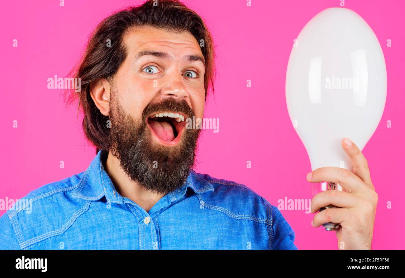 Happy man with lamp. Smiling Bearded man with bulb. Good idea. Birth of ideas. Stock Photo