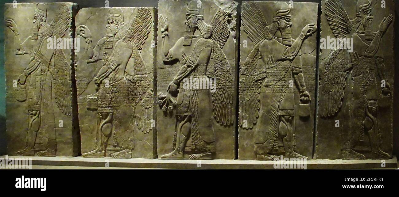 MUNICH - JUL 21, 2018 - WInged and bearded genies with various attributes, Assyrian bas relief, Egyptian Museum, Munich, Germany Stock Photo