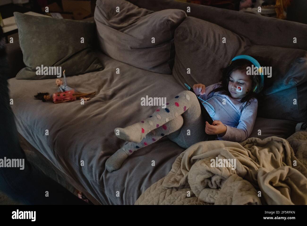 Multiracial girl using digital tablet on couch Stock Photo