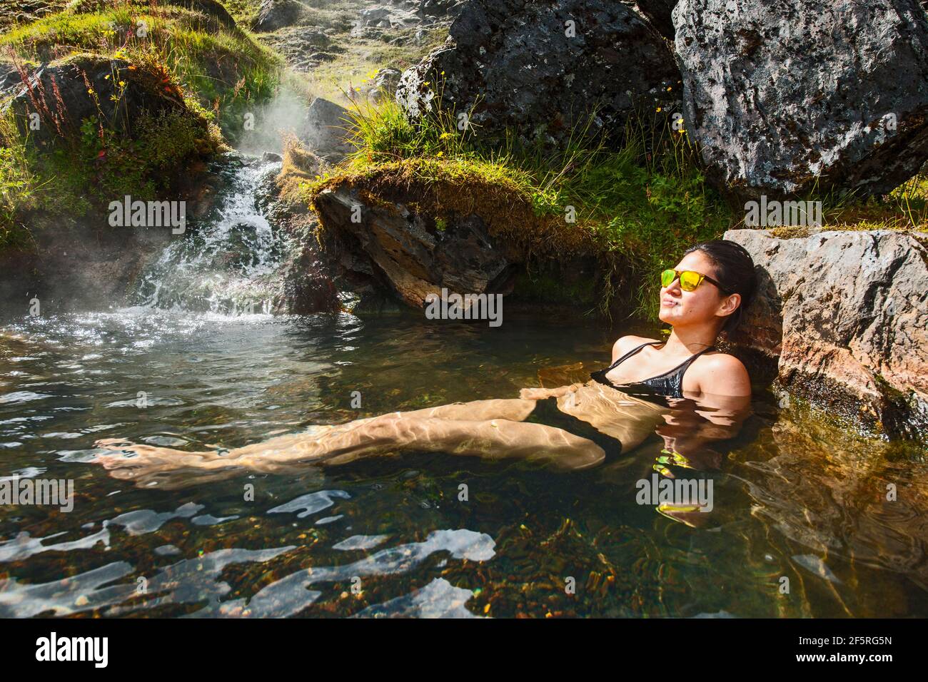 Woman enjoying bath in natural hot spring at Landmannalaugar Stock Photo