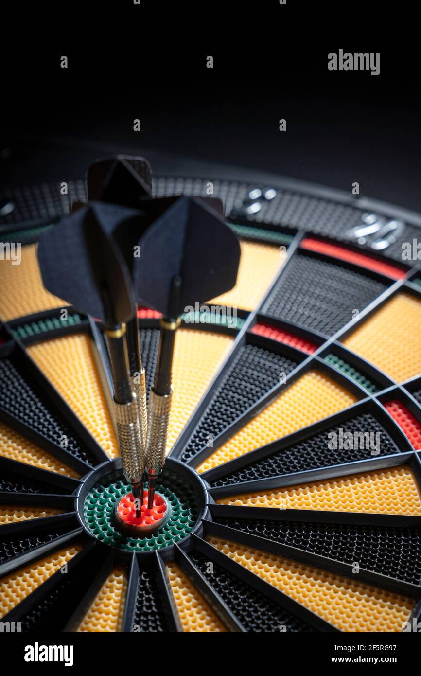 Three darts in bullseye of dartboard Stock Photo