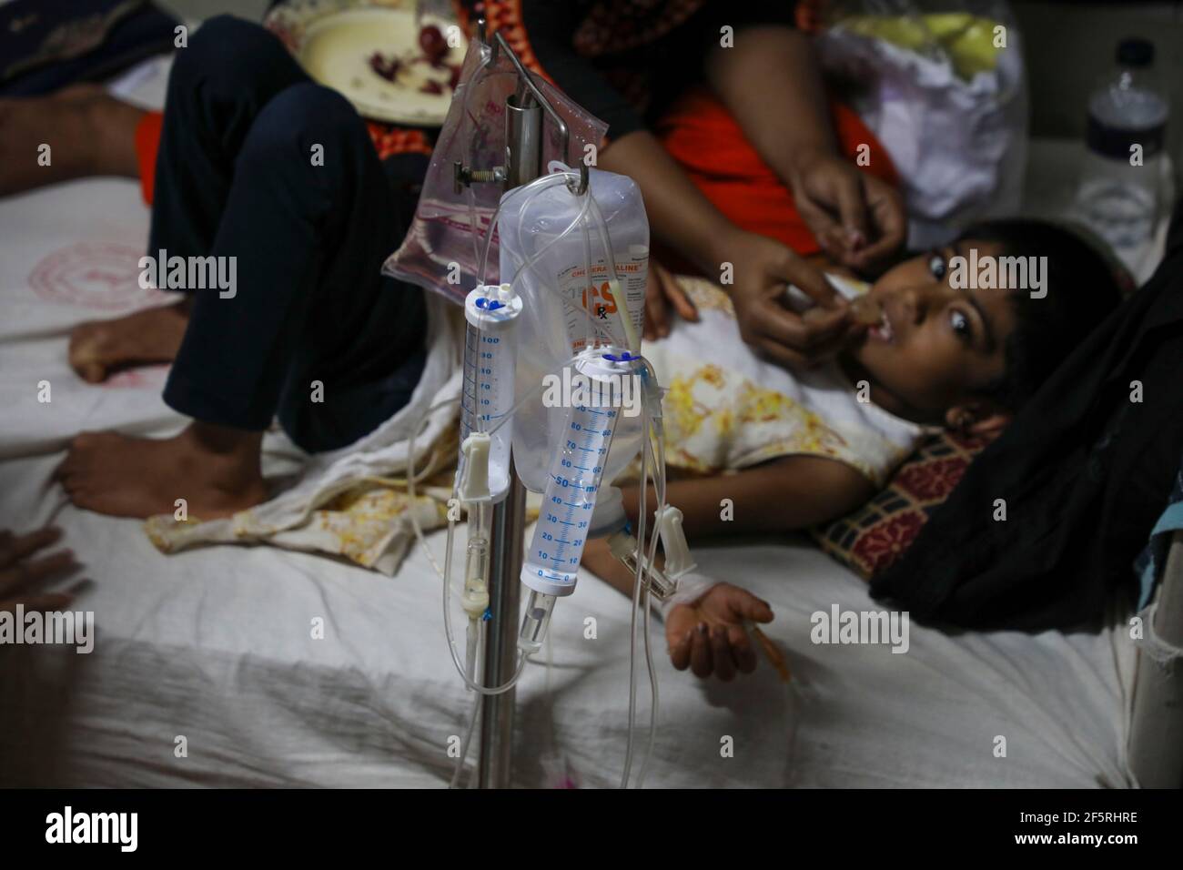 A tripod with infusion solutions beside a mosquito-borne viral dengue fever patient at a hospital in Dhaka, Bangladesh Stock Photo
