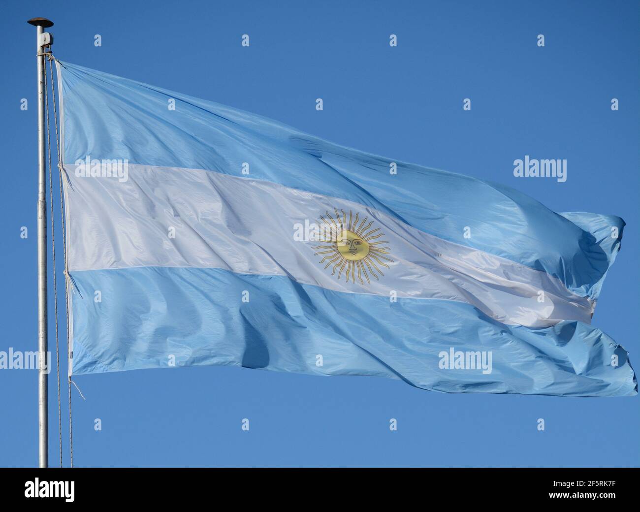 Flag of the Argentine Republic celeste and fluttering in mast with blue sky in background Stock Photo