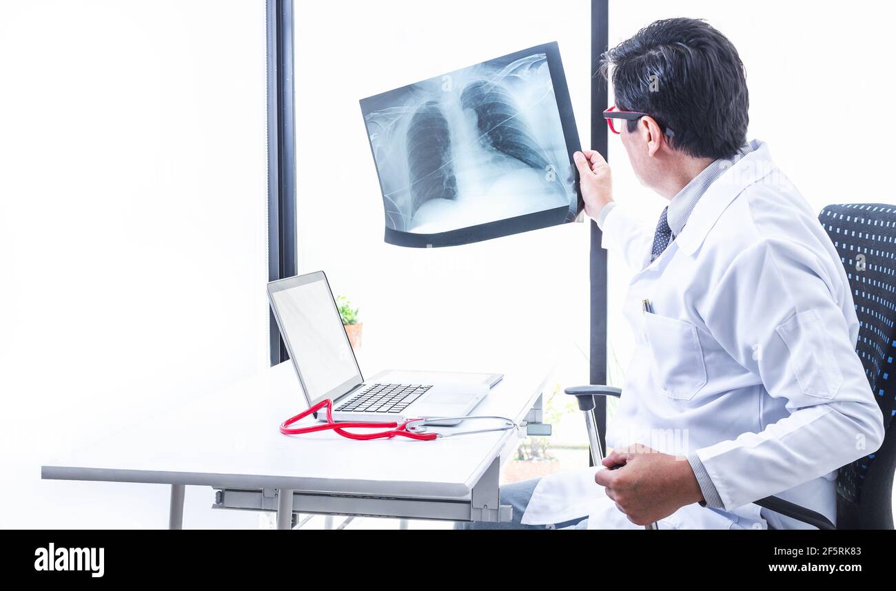 Physician reviewing a chest and lung Xray against the light of the