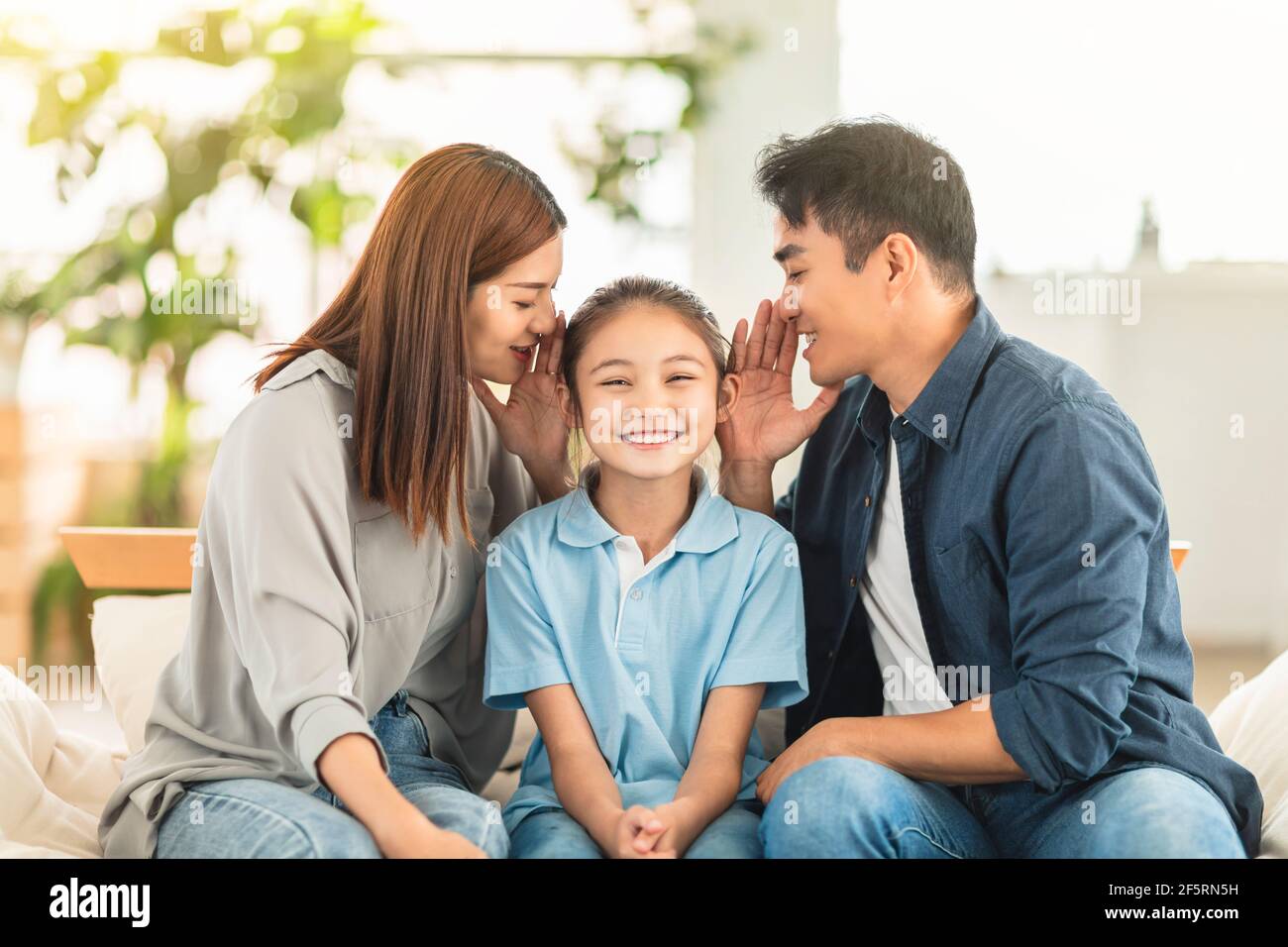 Happy family and child whispering gossip Stock Photo