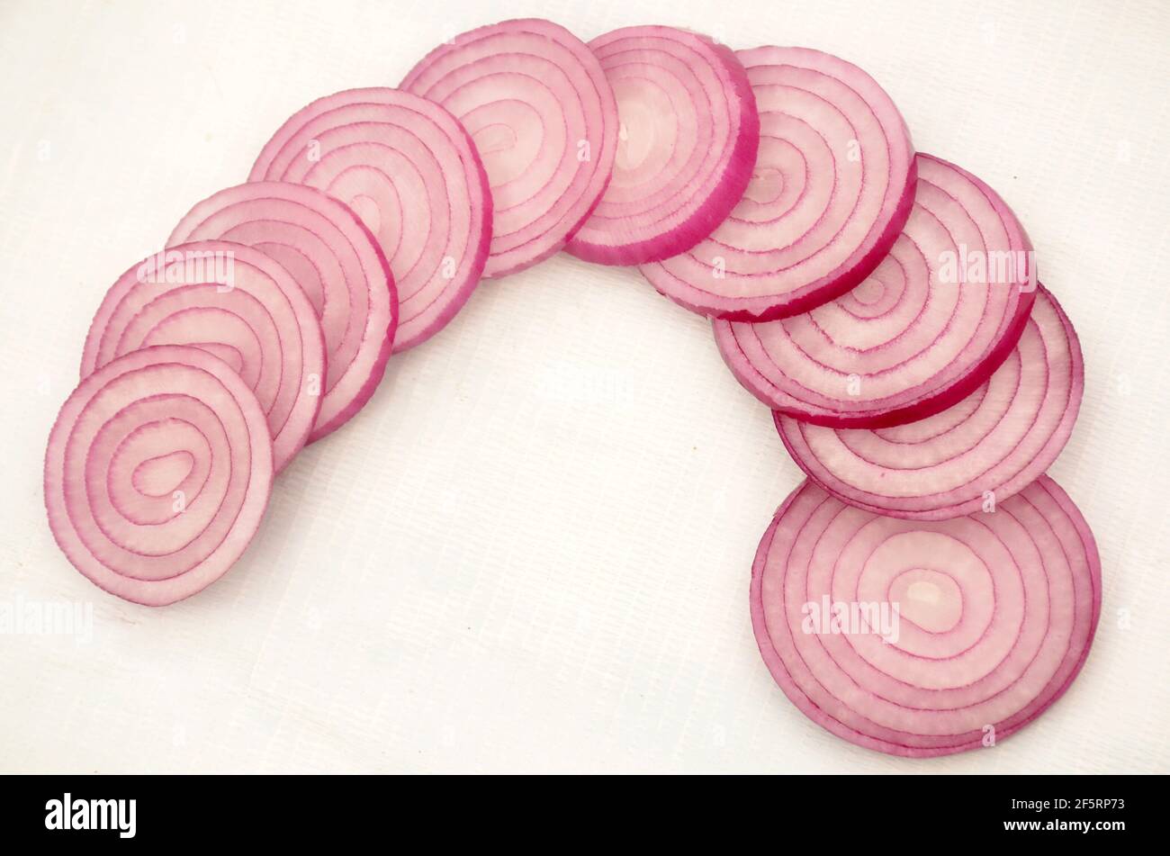A top view of freshly sliced onion rings on a white surface Stock Photo ...