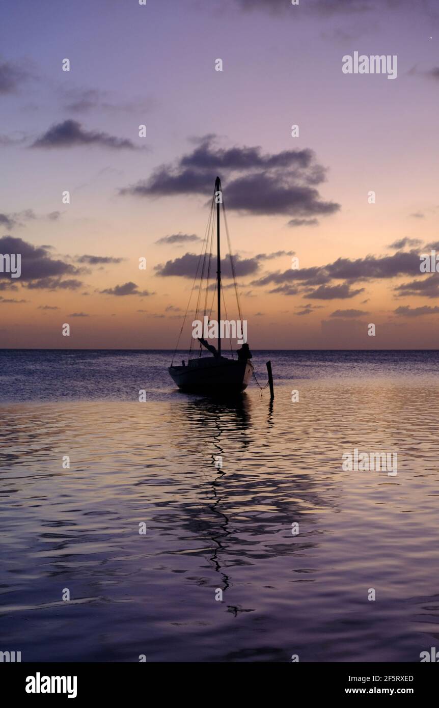 Belize Caye Caulker Island - Sailing boat anchoring at sunset Stock Photo